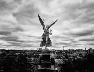 Der Friedensengel vor Münchens Stadtbild in schwarz-weiß. Fotografie von James Murray.