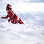 Roter Spielzeug-Dinosaurier in den französischen Alpen. Fotografie von James Murray.